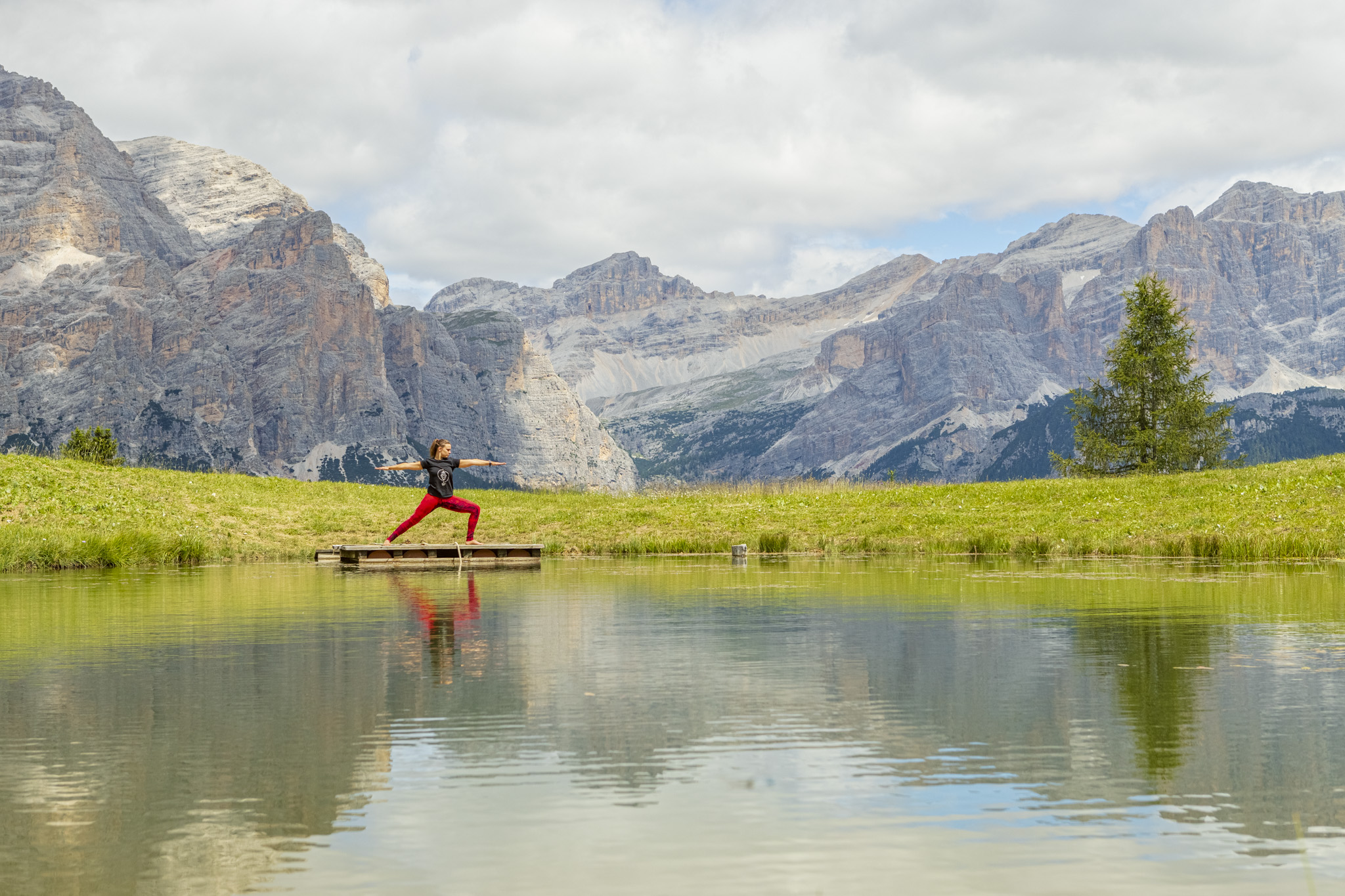 Practice yoga in front of a lake surrounded by astonishing Dolomites of Alta Badia